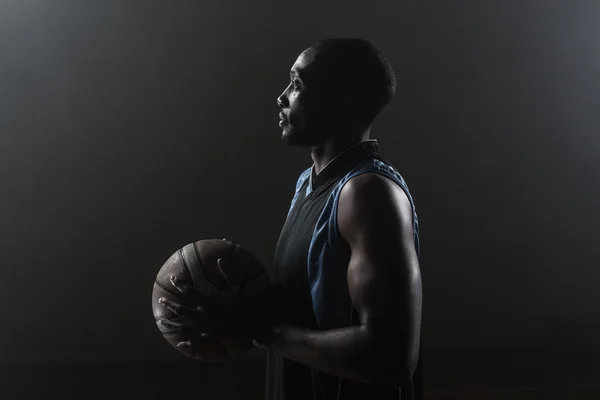 Één kant van een basketbalspeler bezit is van een basketbal — Stockfoto