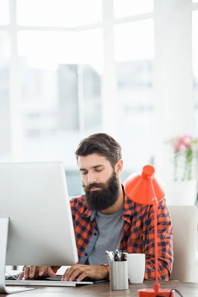 Bir hipster adam onun bilgisayar üzerinde çalışıyor — Stok fotoğraf