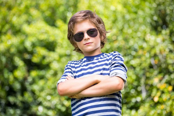 Retrato de menino bonito com óculos de sol posando com braços cruzados — Fotografia de Stock