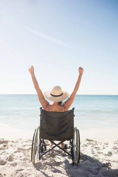 Женщина в инвалидном кресле сидит с поднятыми руками — стоковое фото