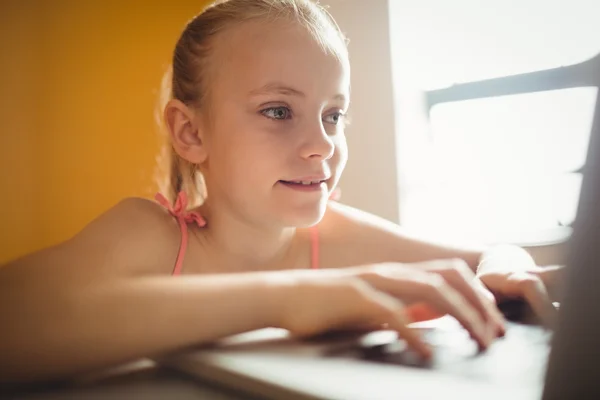 Zittende meisje thuis een computer gebruikt — Stockfoto