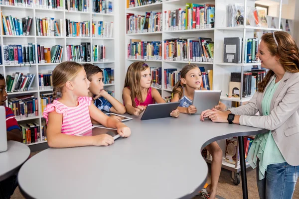 Jonge mooie leraar hebben les aan kinderen met hun tafel — Stockfoto