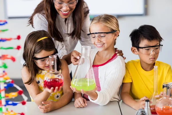 Läraren hjälper eleverna gör vetenskap — Stockfoto