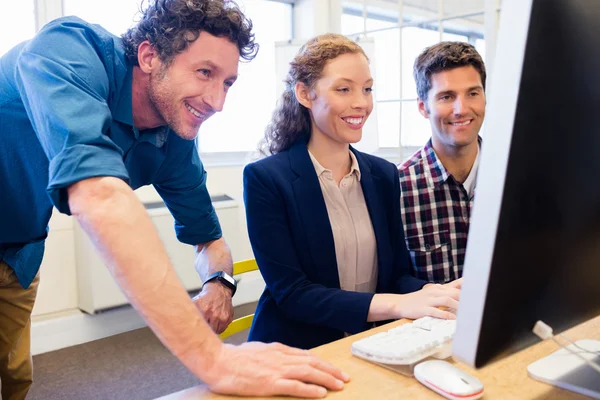 Бизнесмены улыбаются и смотрят в компьютер — стоковое фото
