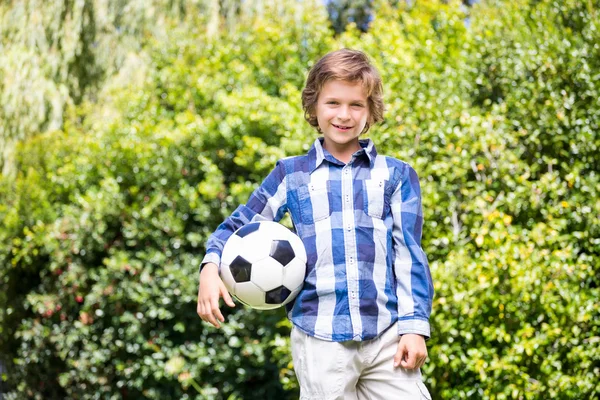 Portret van schattige jongen lachend en houden van een voetbal — Stockfoto