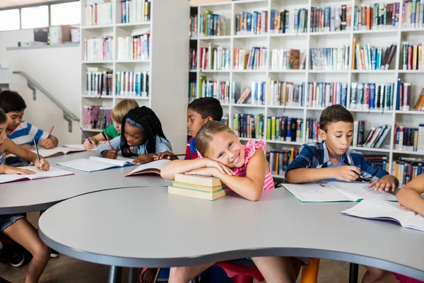 Little girl posing arm crossed at desk — Stock Photo, Image