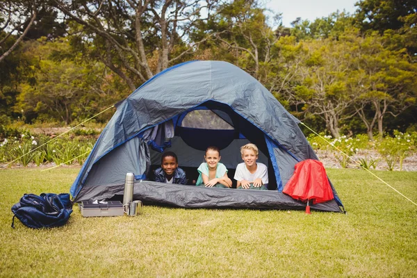 Crianças deitadas e sorrindo em uma tenda — Fotografia de Stock