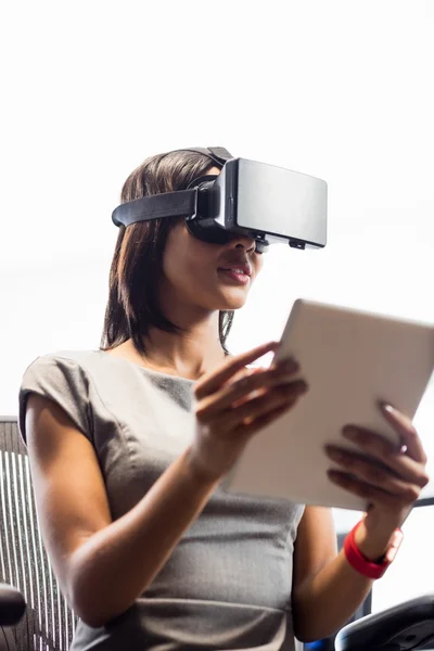 Mujer de negocios mirando su tableta mientras usa unas gafas virtuales — Foto de Stock