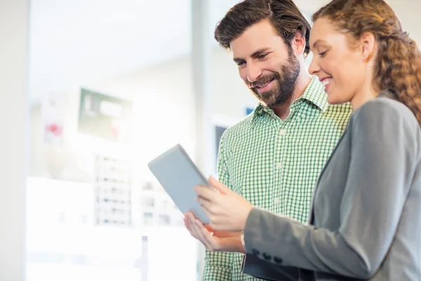 Unternehmer und Geschäftsfrau diskutieren über den Einsatz digitaler Tablets — Stockfoto