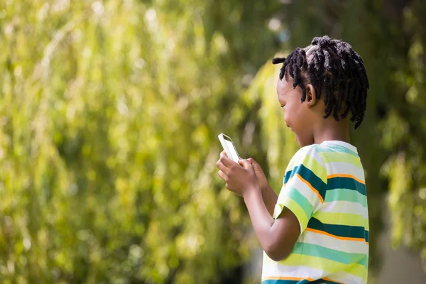 Ett barn leker med en mobiltelefon — Stockfoto