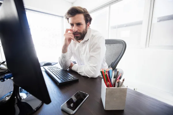 A pensive man looking at his computer — Stock Photo, Image