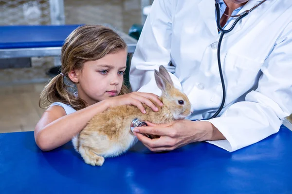Маленькая девочка гладит своего больного кролика — стоковое фото