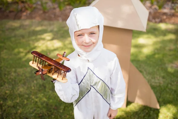 Ritratto di ragazzo carino con abito da astronauta che tiene un piccolo aereo — Foto Stock