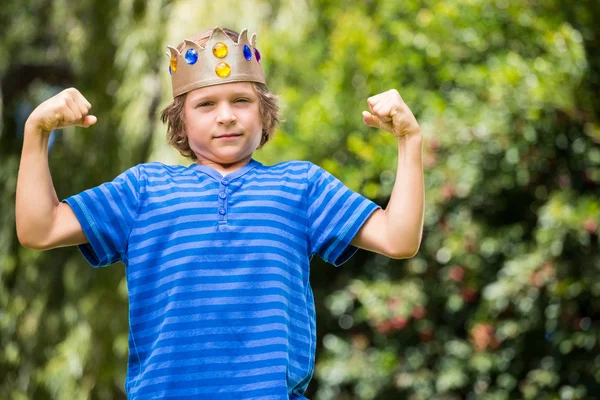 Cute boy with a crown showing his muscles — Stock Photo, Image