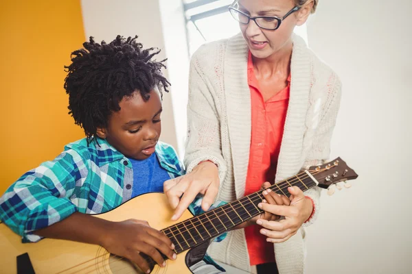 Boy learning how to play the guitar — Stock Photo, Image