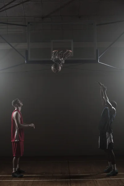 Due giocatori di basket in una palestra con uno che segna un tiro — Foto Stock