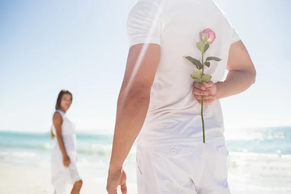 Close up of man holding a rose behind him — Stock Photo, Image