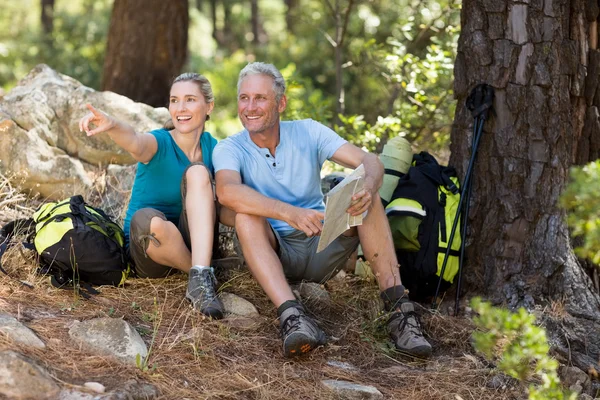 Pareja apuntando y sosteniendo un mapa — Foto de Stock