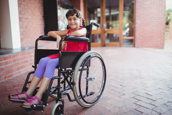 Menina sorridente sentado em uma cadeira de rodas — Fotografia de Stock