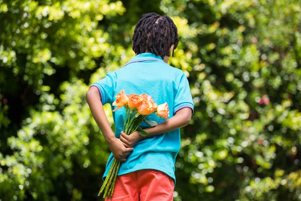 A kid hiding bouquet behind back — Stock Photo, Image
