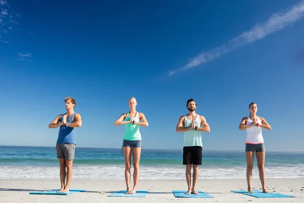 练瑜伽在海滩上的人 — 图库照片