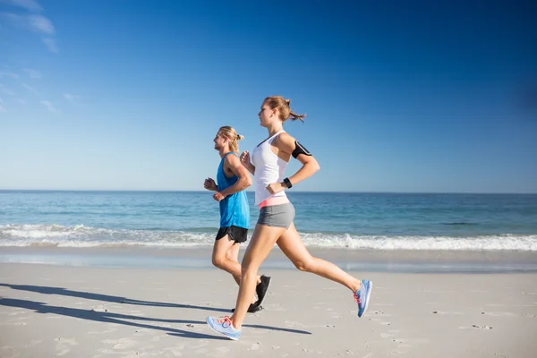 Freunde joggen am Strand — Stockfoto