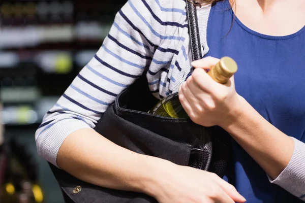 Жінка поклала пляшку вина у свою сумку — стокове фото