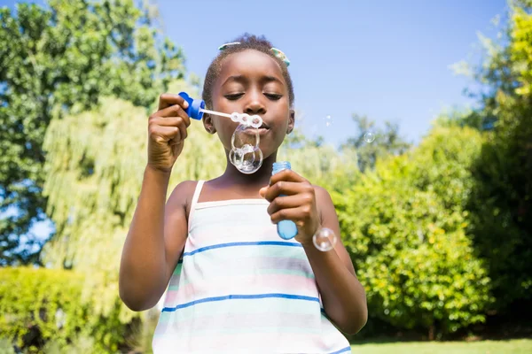 Söt blandras tjej ler och spelar med bubblor — Stockfoto