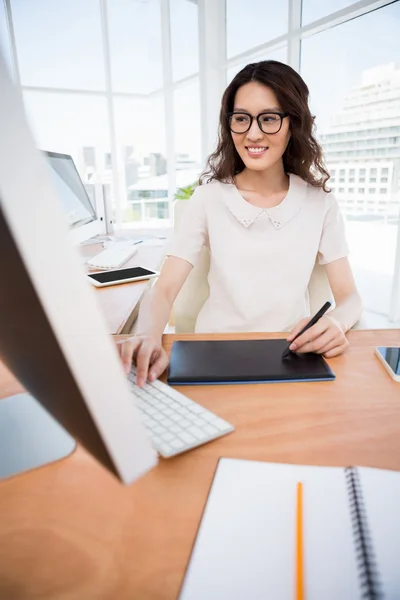 Una mujer está sentada en su escritorio — Foto de Stock