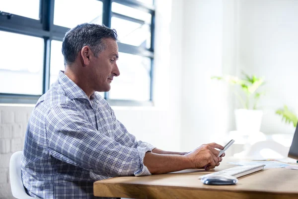 Profile view of a serious man using a smartphone — Stock Photo, Image