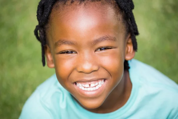 Ragazzo sorridente seduto sull'erba — Foto Stock