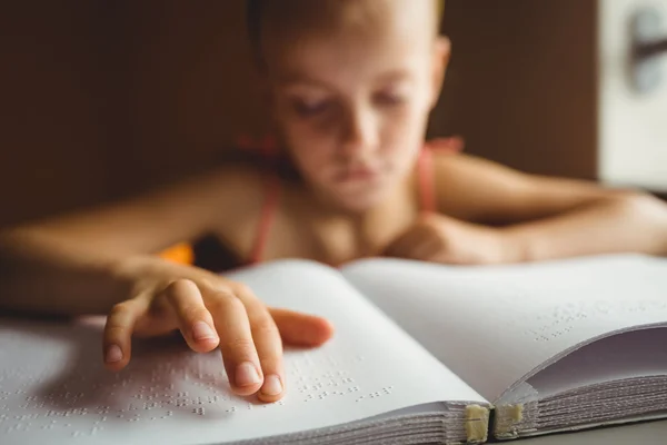 Liten flicka med sin högra hand för att läsa blindskrift — Stockfoto