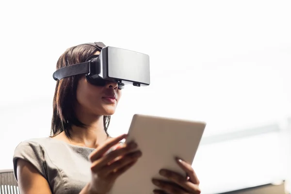 Empresária olhando seu tablet ao usar um óculos virtuais — Fotografia de Stock