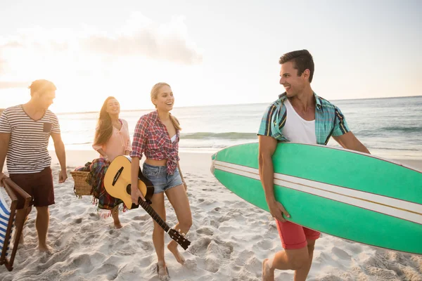 Arkadaşlar bir sörf tahtası ve sepet taşıma — Stok fotoğraf