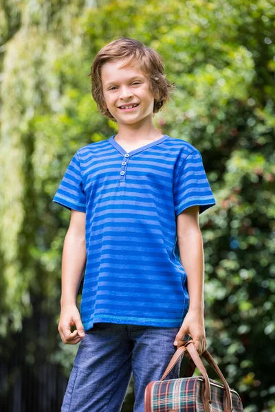 Un niño pequeño sostiene una maleta. — Foto de Stock