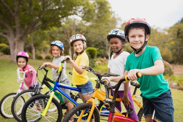 Enfants portant un casque et posant sur leur vélo — Photo