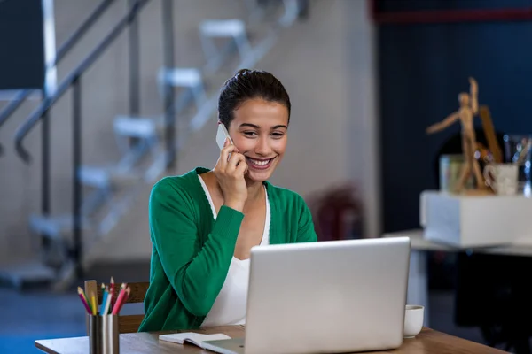 Sorrindo mulher trabalhando na mesa e ter um telefonema — Fotografia de Stock
