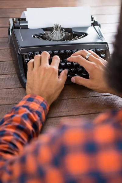 Hipster man använder en skrivmaskin — Stockfoto