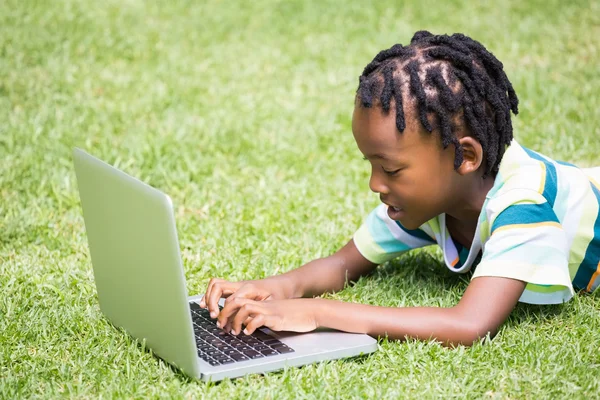 Dziecko leży i grając z jego laptop — Zdjęcie stockowe