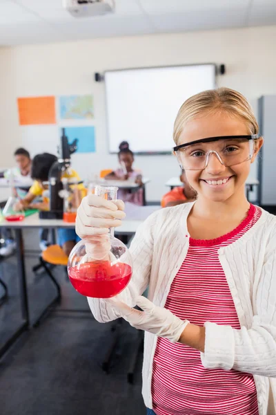 Vista frontal de un alumno feliz posando con un vaso de precipitados —  Fotos de Stock