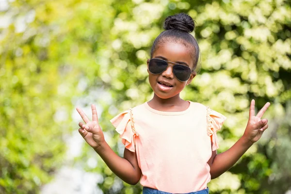 Маленька дівчинка в сонцезахисних окулярах в парку — стокове фото