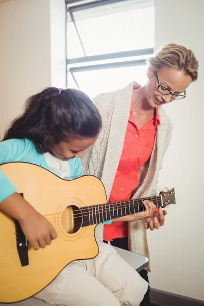 Flicka lära sig att spela gitarr — Stockfoto