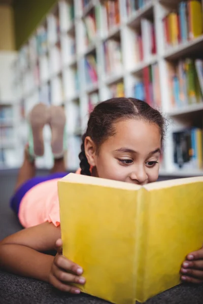 Close up de menina mentindo e lendo um livro — Fotografia de Stock