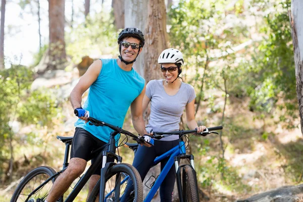 Casal sorrindo e posando com suas bicicletas — Fotografia de Stock