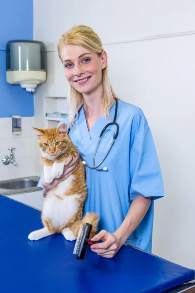 Uma mulher veterinária posando e sorrindo com um gato — Fotografia de Stock