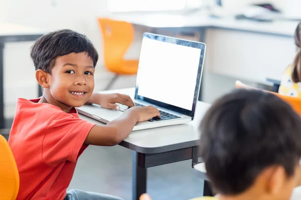 Netter Schüler mit Laptop am Schreibtisch — Stockfoto