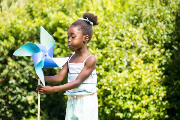 Leuk gemengd ras meisje speelt met een windmolen — Stockfoto