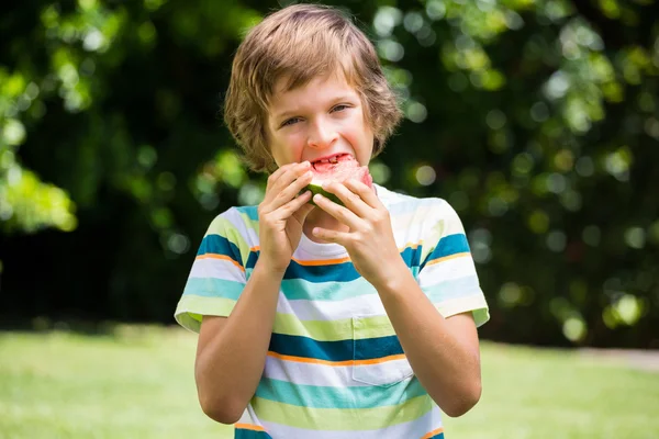 En liten pojke som äter en vattenmelon — Stockfoto