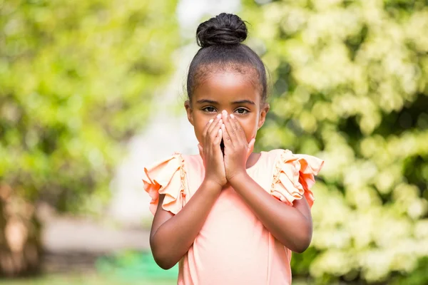 Niña escondiendo su boca en el parque —  Fotos de Stock