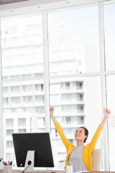 Une femme joyeuse à son bureau — Photo